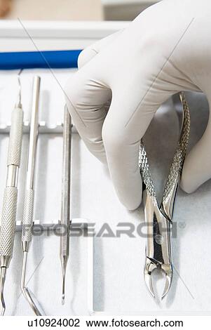 Dental tools with a gloved hand View Large Photo Image Stock Image - Dental tools with a gloved hand. Fotosearch