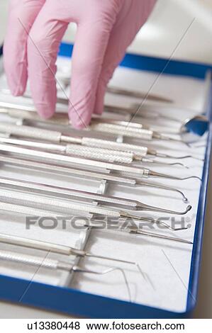 Dental tools with a gloved hand View Large Photo Image Stock Photo - Dental tools with a gloved hand. Fotosearch