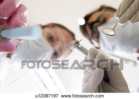 Dentist and assistant holding pick and mirror View Large Photo Image Stock Photo - Dentist and assistant holding pick and mirror. Fotosearch