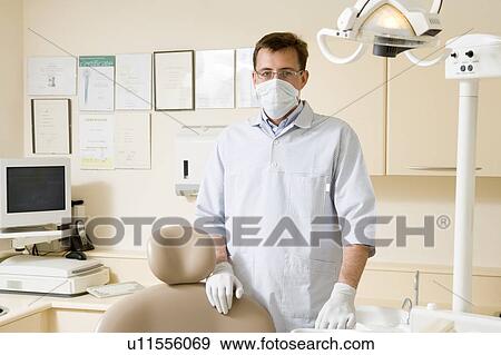 Stock Photo - Dentist in exam room with mask on. Fotosearch