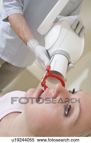 Stock Photography - Dentist in exam room with woman in chair. Fotosearch