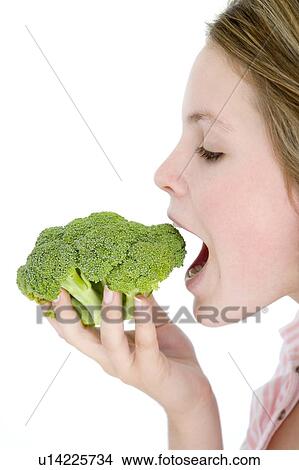 Teenage girl eating broccoli View Large Photo Image Picture - Teenage girl eating broccoli. Fotosearch