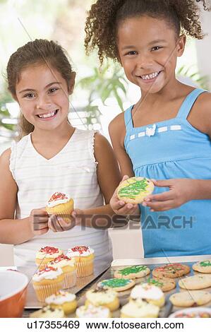 Two children in kitchen decorating cookies smiling View Large Photo Image Stock Photo - Two children in kitchen decorating cookies smiling. Fotosearch