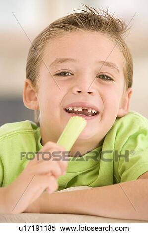 Young boy eating celery in living room smiling View Large Photo Image Stock Photography - Young boy eating celery in living room smiling. Fotosearch