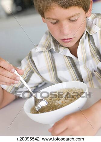 Young boy in kitchen eating soup View Large Photo Image Stock Image - Young boy in kitchen eating soup. Fotosearch