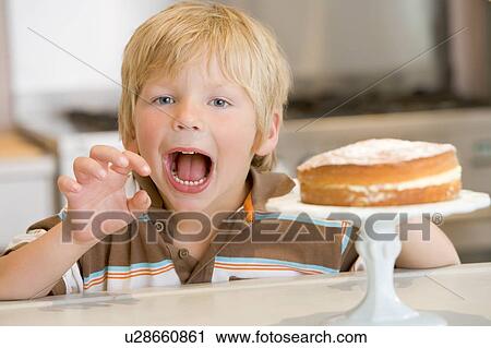 Young boy in kitchen with cake on counter View Large Photo Image Stock Image - Young boy in kitchen with cake on counter. Fotosearch