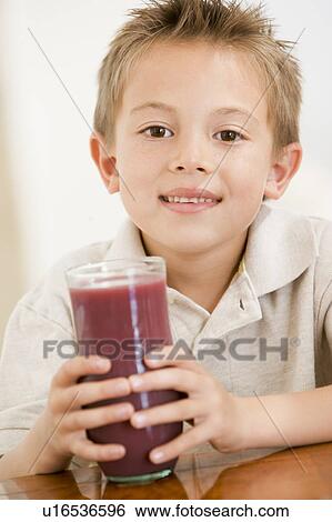 Young boy indoors drinking juice smiling View Large Photo Image Stock Photograph - Young boy indoors drinking juice smiling. Fotosearch