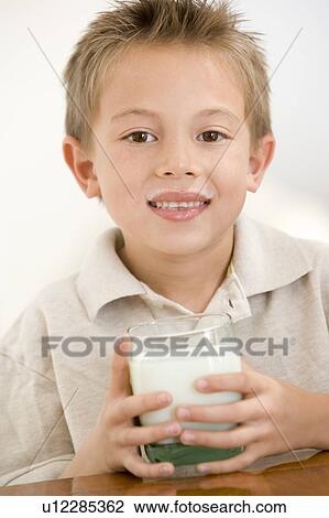 Young boy indoors drinking milk smiling View Large Photo Image Stock Image - Young boy indoors drinking milk smiling. Fotosearch