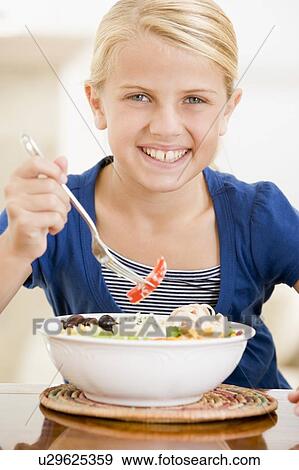 Young girl indoors eating seafood smiling View Large Photo Image Stock Photo - Young girl indoors eating seafood smiling. Fotosearch