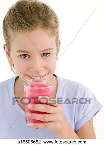 Stock Image - Young girl with glass of juice smiling. Fotosearch