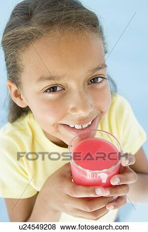 Young girl with glass of juice smiling View Large Photo Image Stock Photo - Young girl with glass of juice smiling. Fotosearch