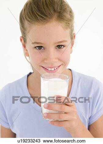 Stock Image - Young girl with glass of milk smiling. Fotosearch