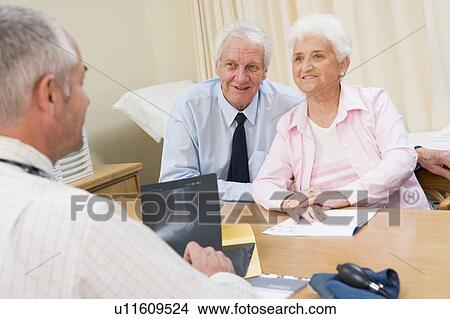 Picture - Couple in doctor's office smiling. Fotosearch