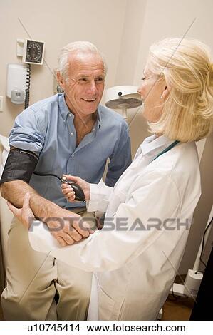 Doctor Checking Blood Pressure Of Man View Large Photo Image Picture - Doctor Checking Blood Pressure Of Man. Fotosearch