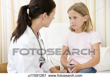 Stock Photo - Doctor giving checkup to young girl in exam room. Fotosearch