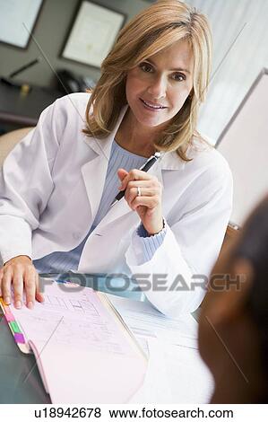 Stock Photo - Doctor in consultation with man at IVF clinic (selective focus). Fotosearch