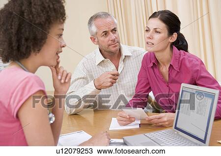 Doctor with laptop and couple in doctor's office frowning View Large Photo Image Stock Image - Doctor with laptop and couple in doctor's office frowning. Fotosearch