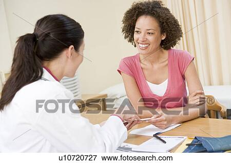 Stock Photo - Woman in doctor's office smiling. Fotosearch