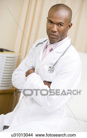 Picture - A Doctor Sitting On A Hospital Bed. Fotosearch