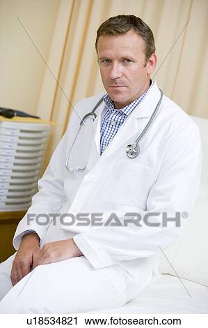 Stock Image - A Doctor Sitting On A Hospital Bed. Fotosearch