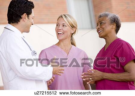 Stock Image - Doctor And Nurses Standing Outside A Hospital. Fotosearch