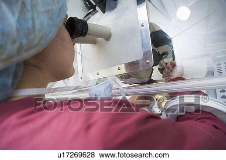 Stock Photo - Embryologist adding sperm to egg. Fotosearch