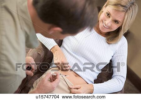 Picture - Man helping woman inject drugs to prepare for IVF treatment (selective focus). Fotosearch
