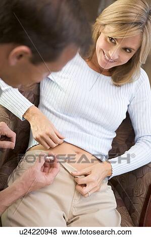 Stock Photo - Man helping woman inject drugs to prepare for IVF treatment (selective focus). Fotosearch