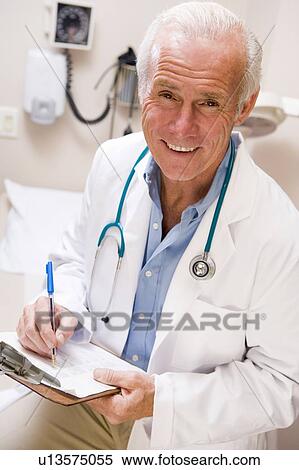 Middle Aged Doctor Writing On His Clipboard View Large Photo Image Stock Photography - Middle Aged Doctor Writing On His Clipboard. Fotosearch