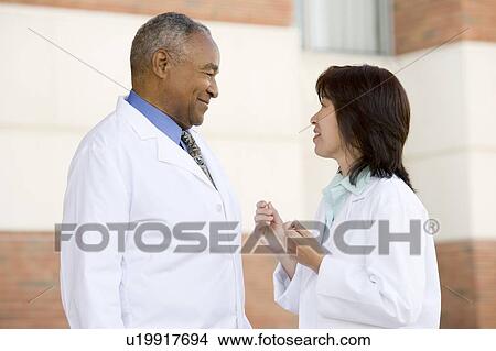 Two Doctors Standing Outside A Hospital View Large Photo Image Picture - Two Doctors Standing Outside A Hospital. Fotosearch