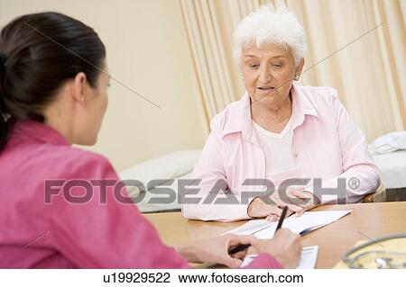 Stock Image - Woman in doctor's office frowning. Fotosearch