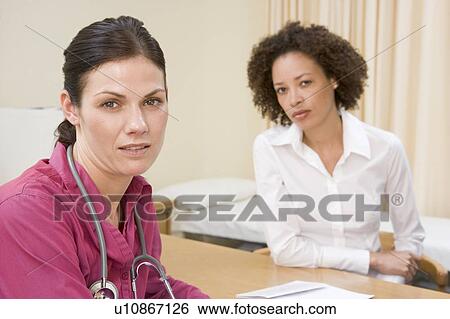 Stock Photograph - Woman in doctor's office frowning. Fotosearch