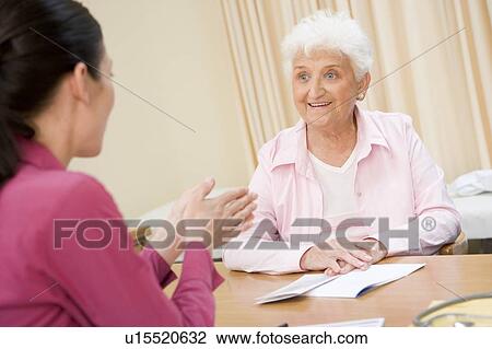Stock Image - Woman in doctor's office smiling. Fotosearch