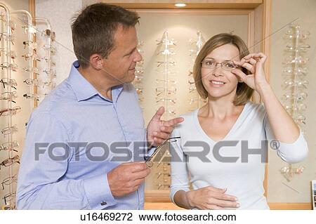 Couple trying on eyeglasses at optometrists smiling View Large Photo Image Stock Image - Couple trying on eyeglasses at optometrists smiling. Fotosearch