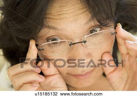 Stock Image - Woman Looking Through New Glasses. Fotosearch