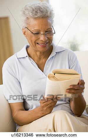 Stock Photograph - Woman relaxing with a book and smiling. Fotosearch