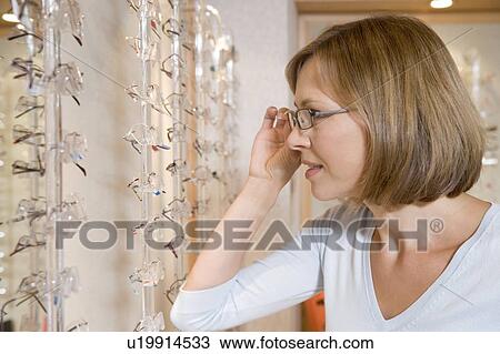Woman trying on eyeglasses at optometrists View Large Photo Image Stock Image - Woman trying on eyeglasses at optometrists. Fotosearch