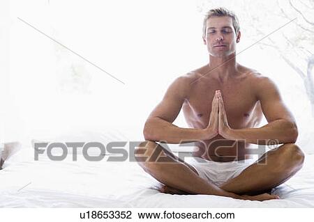 Man sitting on bed meditating View Large Photo Image Stock Image - Man sitting on bed meditating. Fotosearch