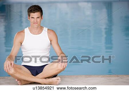 Stock Image - Man sitting poolside smiling. Fotosearch