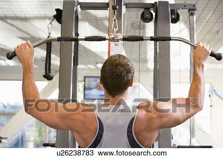Stock Image - Man Weight Training At Gym. Fotosearch