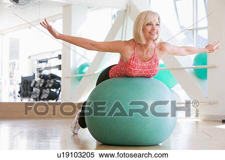 Stock Photography - Woman Balancing On Swiss Ball. Fotosearch