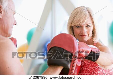 Stock Photograph - Woman Boxing With Personal Trainer At Gym. Fotosearch