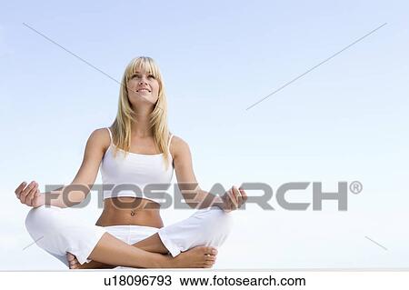Woman sitting and meditating outdoors View Large Photo Image Stock Image - Woman sitting and meditating outdoors. Fotosearch