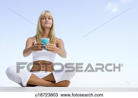 Woman sitting and meditating outdoors while holding a candle View Large Photo Image Stock Image - Woman sitting and meditating outdoors while holding a candle. Fotosearch