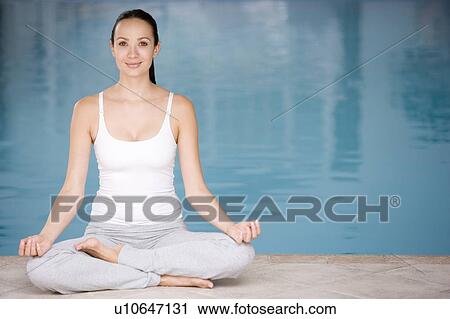 Woman sitting poolside doing yoga View Large Photo Image Stock Image - Woman sitting poolside doing yoga. Fotosearch