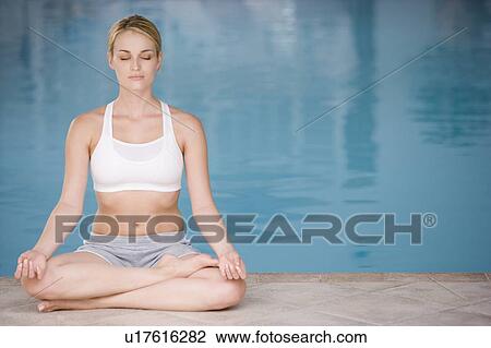 Woman sitting poolside doing yoga View Large Photo Image Stock Image - Woman sitting poolside doing yoga. Fotosearch