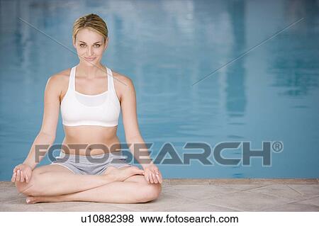 Woman sitting poolside doing yoga smiling View Large Photo Image Stock Photo - Woman sitting poolside doing yoga smiling. Fotosearch
