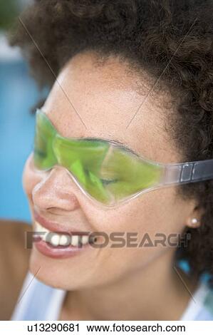 Woman sitting poolside using eye mask smiling View Large Photo Image Stock Image - Woman sitting poolside using eye mask smiling. Fotosearch