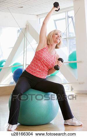 Woman Using Hand Weights On Swiss Ball At Gym View Large Photo Image Picture - Woman Using Hand Weights On Swiss Ball At Gym. Fotosearch