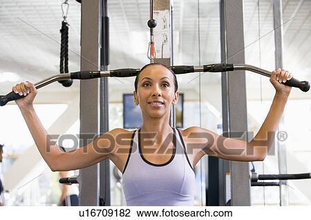 Stock Image - Woman Weight Training At Gym. Fotosearch